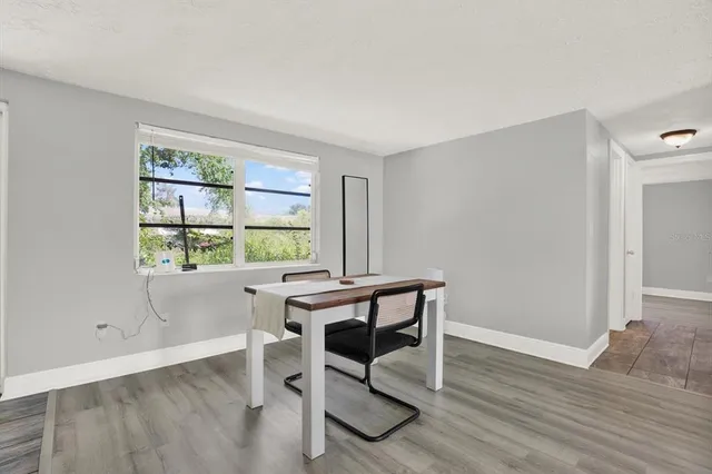 a view of a workspace with wooden floor and a window