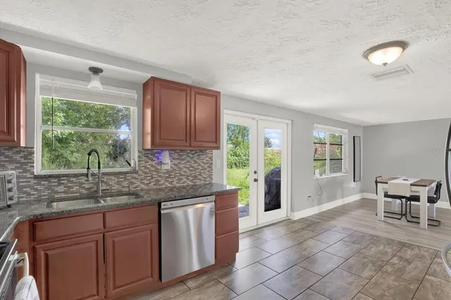 a kitchen with granite countertop a stove a sink and a cabinets