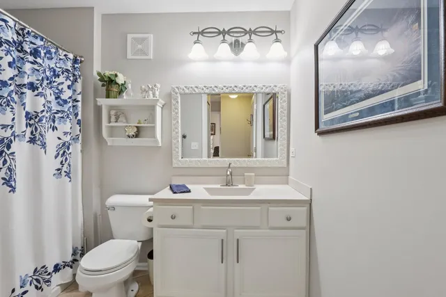 a bathroom with a sink mirror vanity and toilet