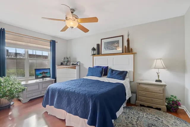 a spacious bedroom with a bed painting on wall and a large window