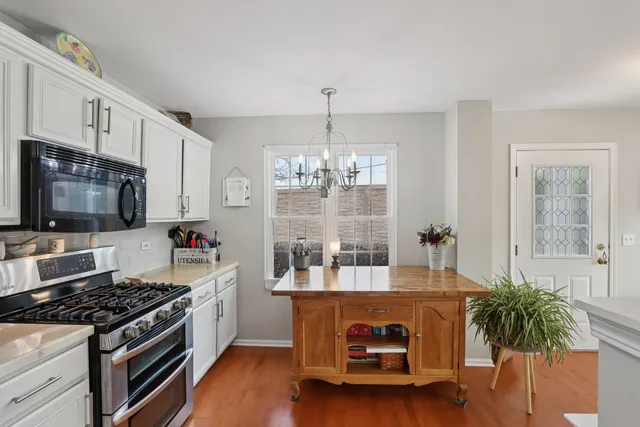 a kitchen with sink a microwave and cabinets
