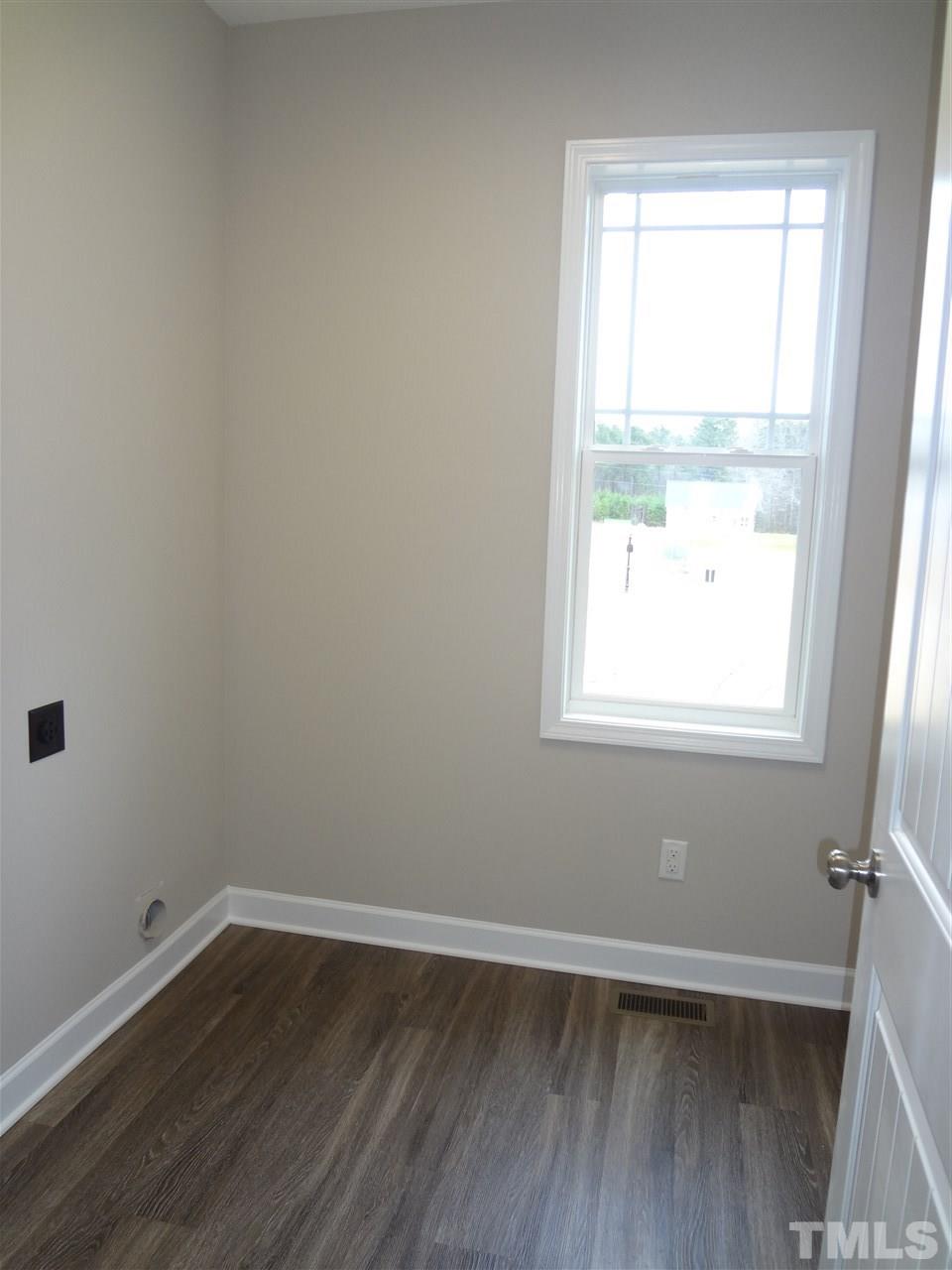 7932 Creech Road Middlesex, NC 27557 - Photo 22 of 25 a view of an empty room with wooden floor and a window