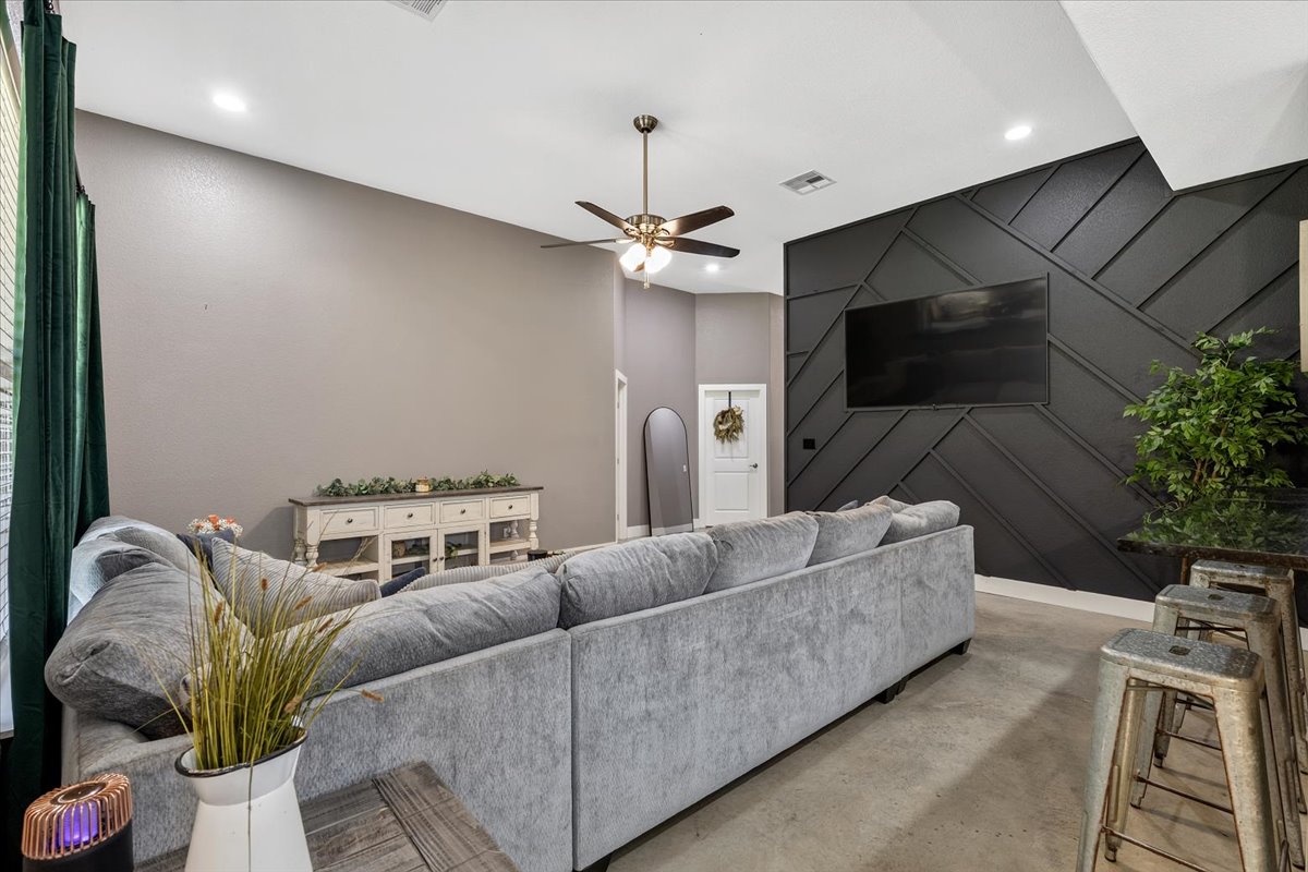 145 Cardinal Loop Paige, TX 78659 - Photo 9 of 40 Concrete floors meet a striking geometric accent wall in this contemporary gathering space.