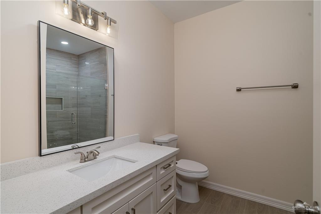 5406 North Crown Point Pharr, TX 78577 - Photo 9 of 14 a bathroom with a granite countertop sink toilet and shower