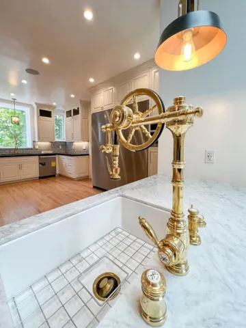 a large kitchen with stainless steel appliances granite countertop a stove a sink and a granite counter tops