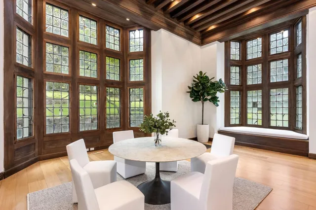 a large kitchen with stainless steel appliances a large counter top a stove a refrigerator and white cabinets