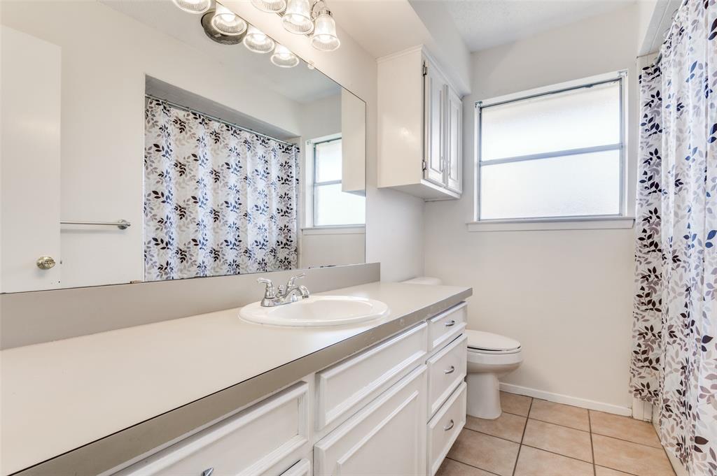 1308 Sundale Street Ennis, TX 75119 - Photo 7 of 12 a bathroom with a sink a toilet and a window