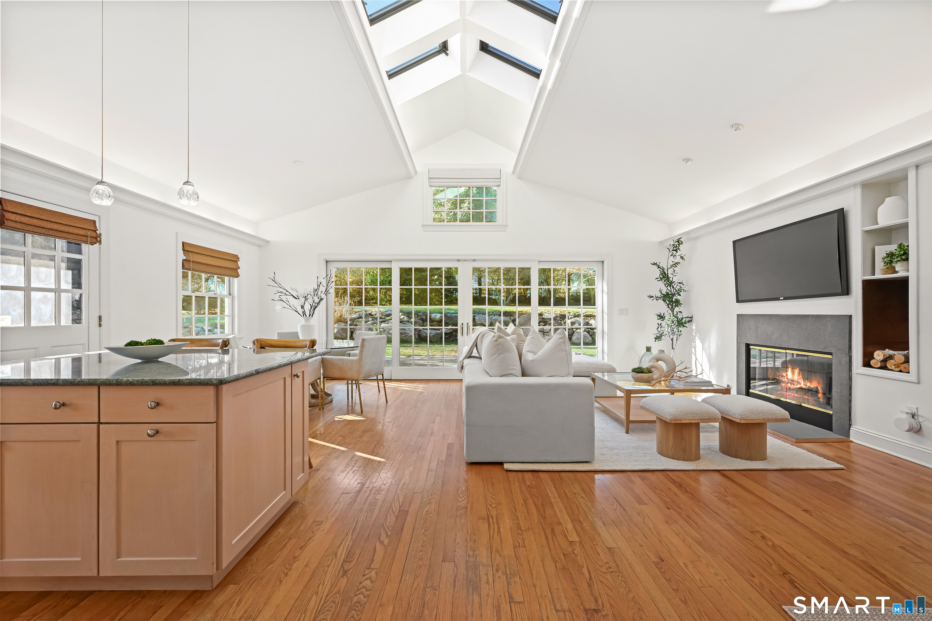 36 MacArthur Lane Stamford, CT 06902 - Photo 5 of 40 Fabulous light-filled Great Room with Living Room, Sitting Area, Dining Area & Kitchen with vaulted ceiling, skylights, cove lighting, wall of sliders and fireplace