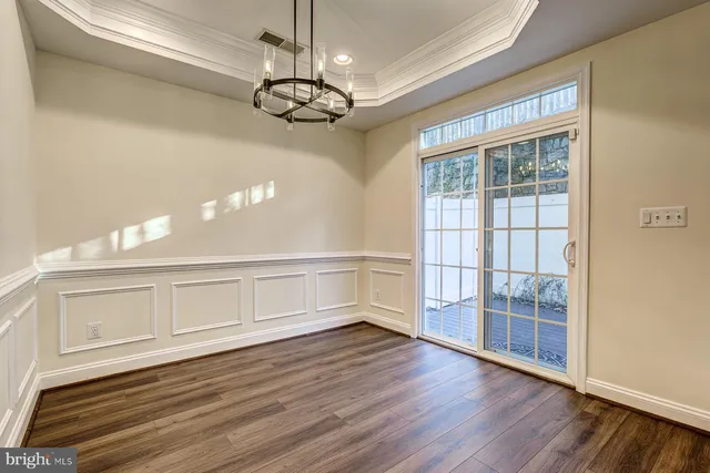 an empty room with wooden floor closet and chandelier fan