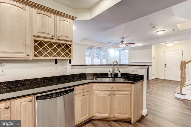 an empty room with wooden floor ceiling fan and windows
