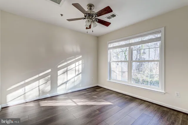 a view of an empty room with wooden floor