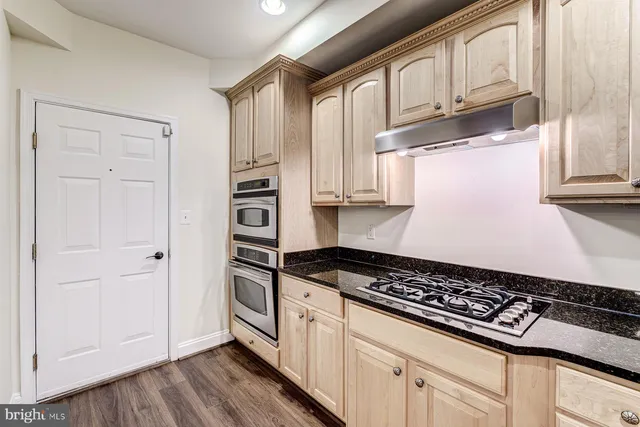 a view of a livingroom with wooden floor and a ceiling fan