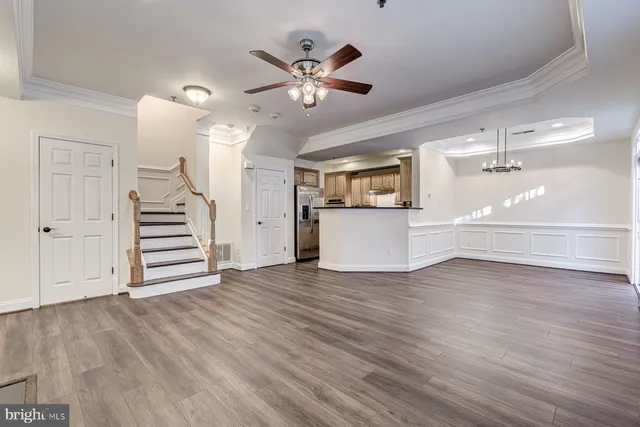 an empty room with windows and ceiling fan