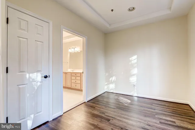 an empty room with wooden floor fireplace and windows