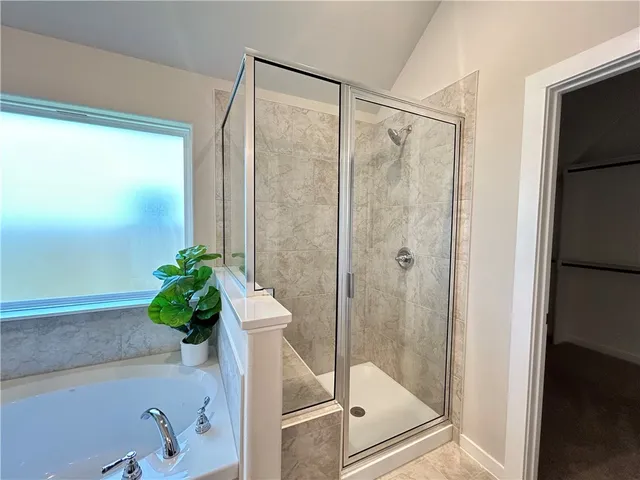 a bath room with a shower and a bath tub