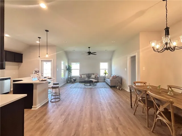 a view of a dining room and livingroom with furniture wooden floor a chandelier
