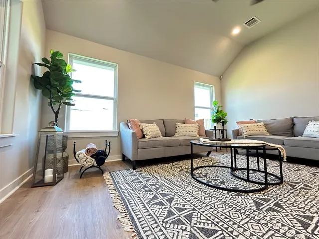 a living room with furniture a window and a potted plant