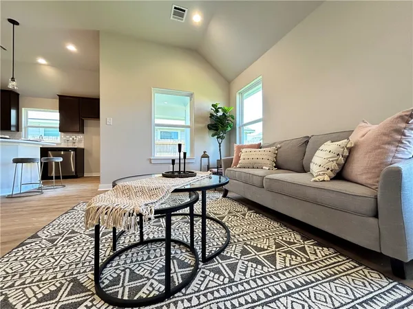 a living room with furniture a flat screen tv and a table