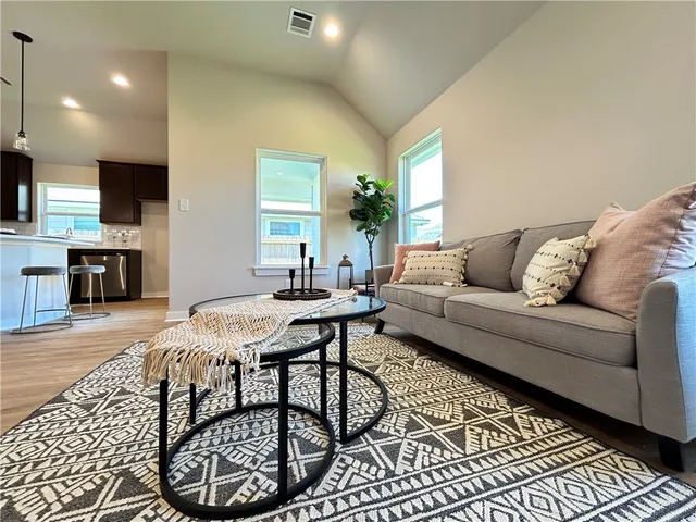a living room with furniture a flat screen tv and a table