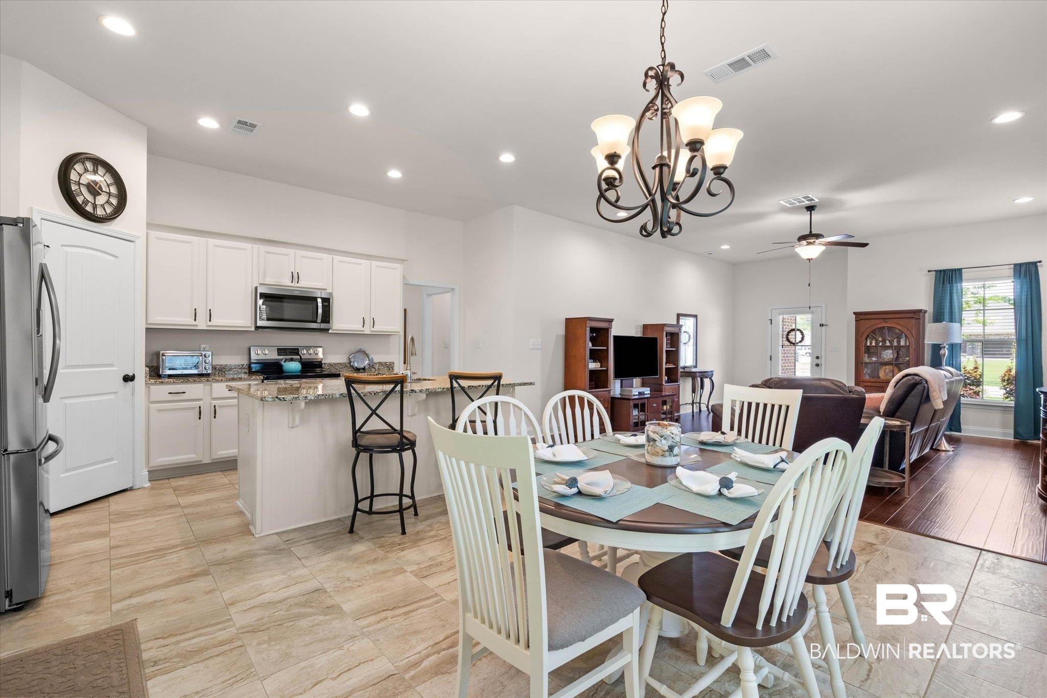 1270 Surrey Loop Foley, AL 36535 - Photo 6 of 27 Open concept living space featuring a kitchen with white cabinetry, stainless steel appliances, and a granite-topped island with seating
