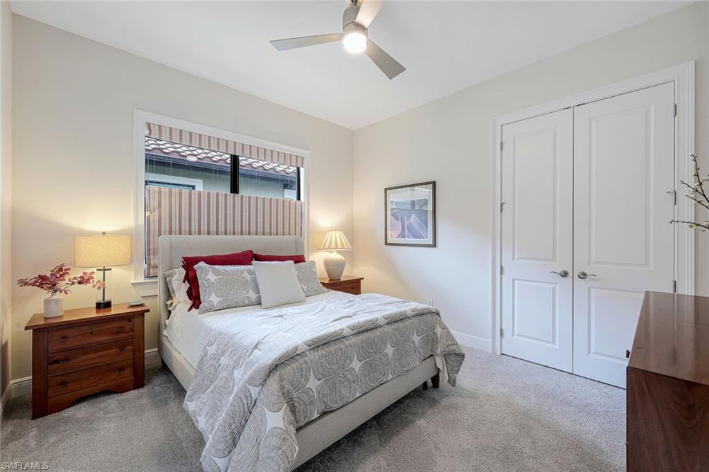 12762 Dundee Lane Naples, FL 34120 - Photo 20 of 35 a bedroom with a bed and a chandelier