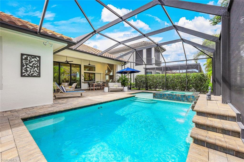 12762 Dundee Lane Naples, FL 34120 - Photo 32 of 35 a view of a patio with couches and table and chairs under an umbrella