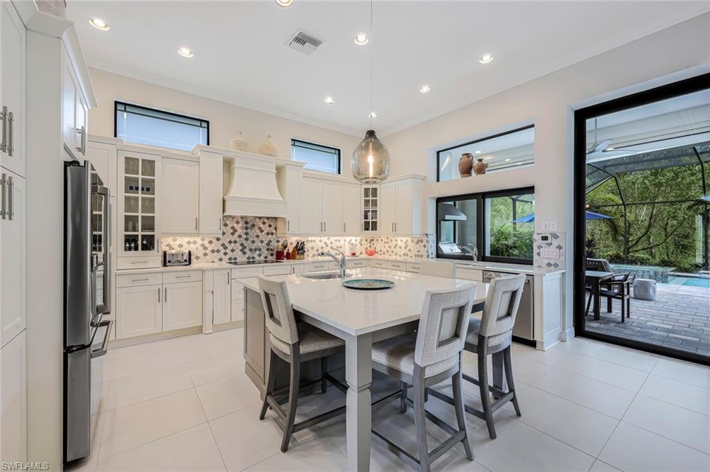 12762 Dundee Lane Naples, FL 34120 - Photo 10 of 35 a kitchen with stainless steel appliances kitchen island granite countertop a refrigerator and a dining table