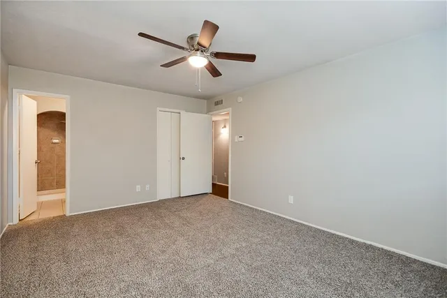 an empty room with windows and fan view