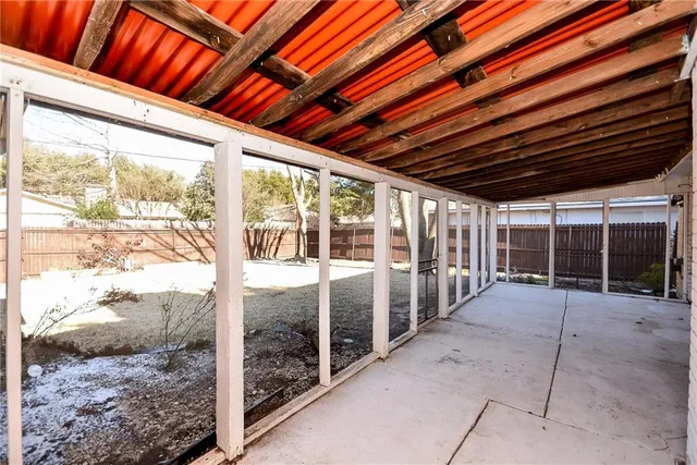 a view of a patio with table and chairs and floor to ceiling window
