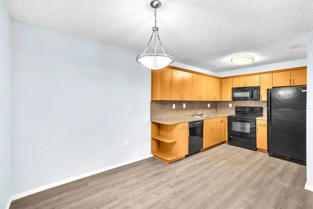 a kitchen with stainless steel appliances granite countertop a refrigerator a sink dishwasher a oven with wooden cabinets