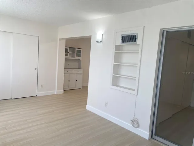 an empty room with windows and closet