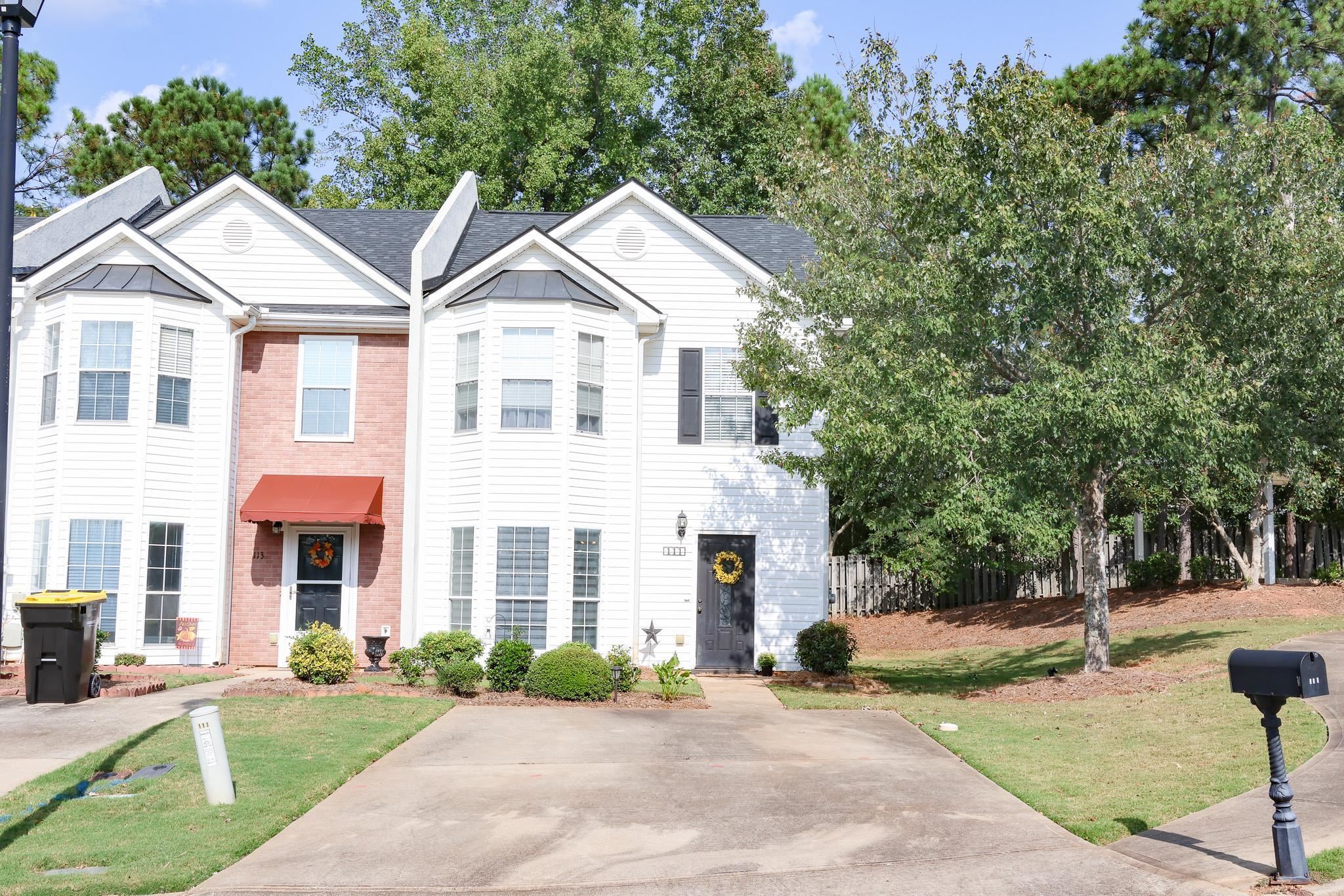 a front view of a house with a yard and trees
