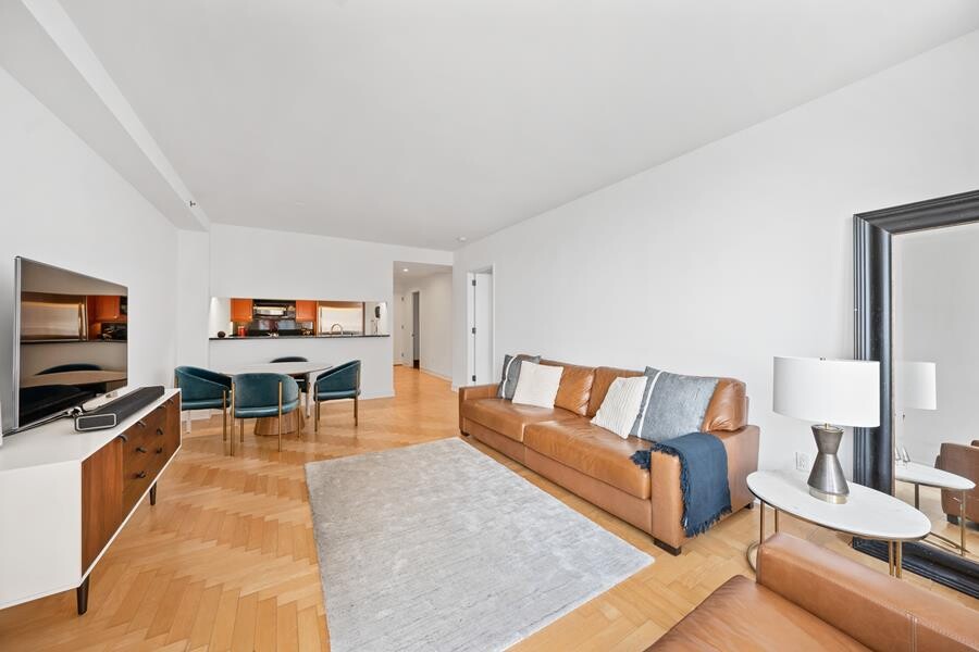 220 Riverside Boulevard, Unit 11G Manhattan, NY 10069 - Photo 2 of 7 a living room with furniture and a flat screen tv