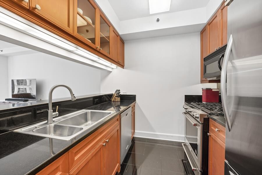 220 Riverside Boulevard, Unit 11G Manhattan, NY 10069 - Photo 5 of 7 a kitchen with stainless steel appliances granite countertop a sink and a stove