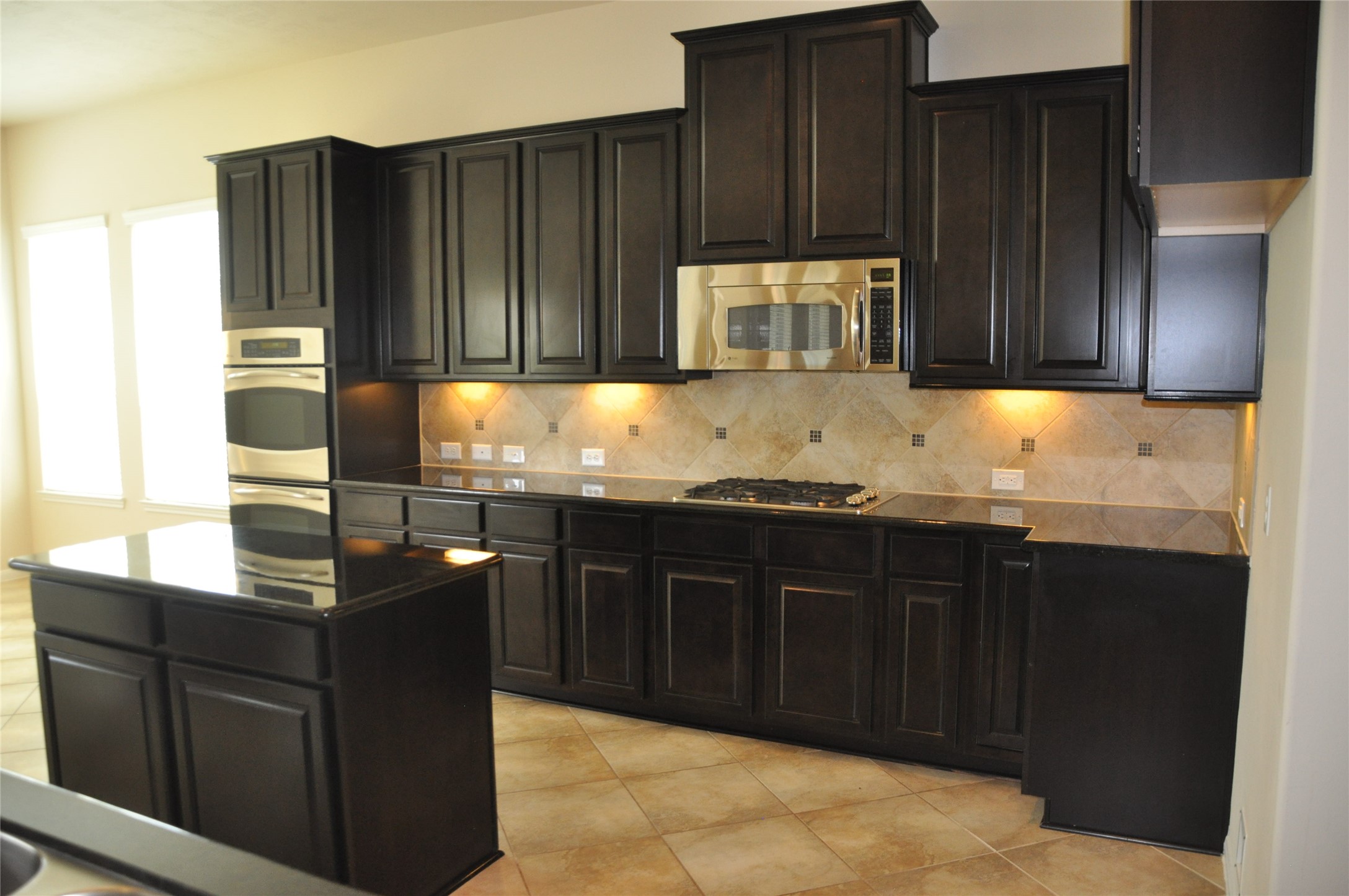 8161 Tranquil Lake Way Conroe, TX 77385 - Photo 14 of 20 a kitchen with granite countertop wooden cabinets and granite counter tops