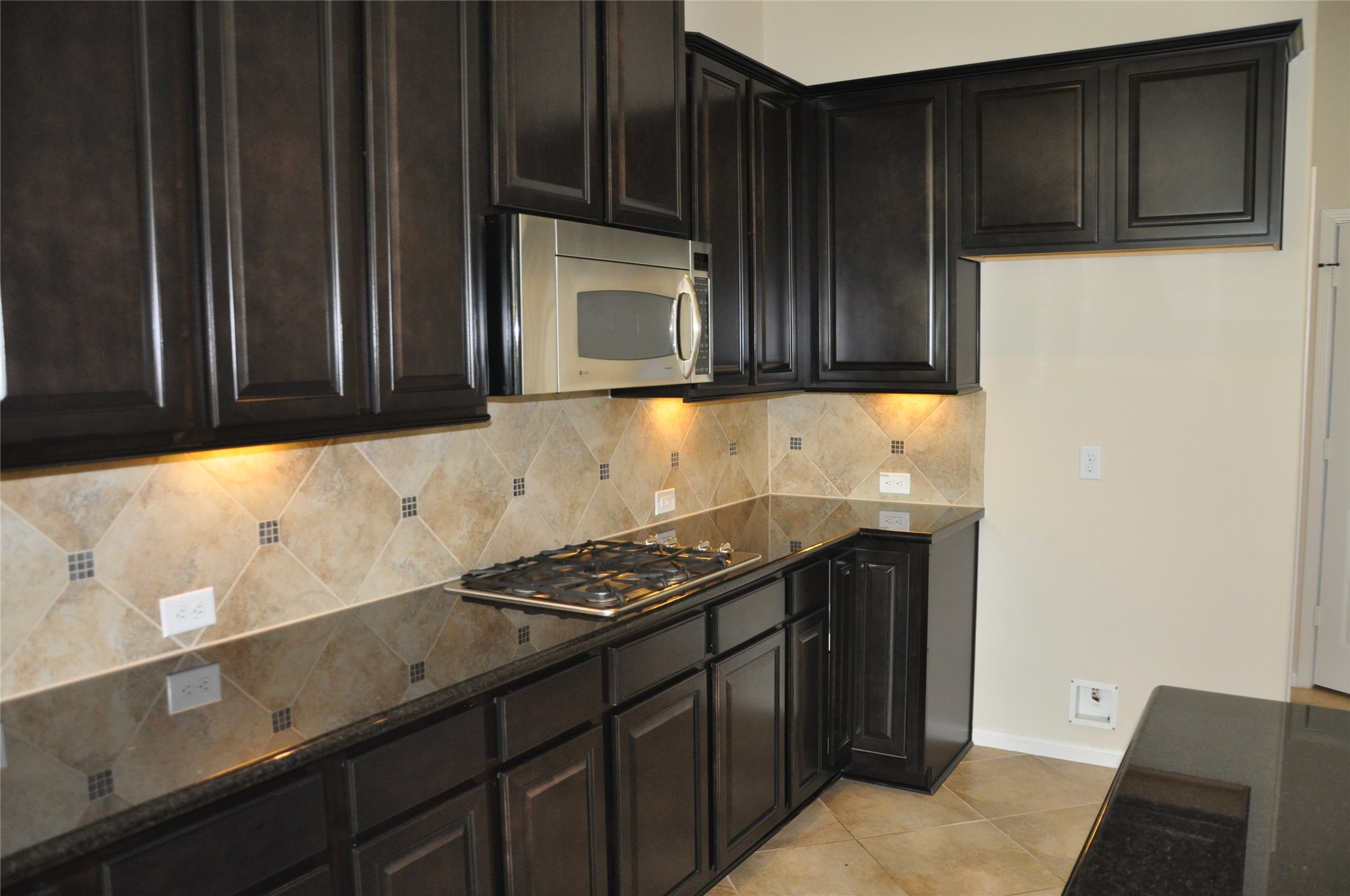 8161 Tranquil Lake Way Conroe, TX 77385 - Photo 10 of 20 a kitchen with granite countertop cabinets and black appliances