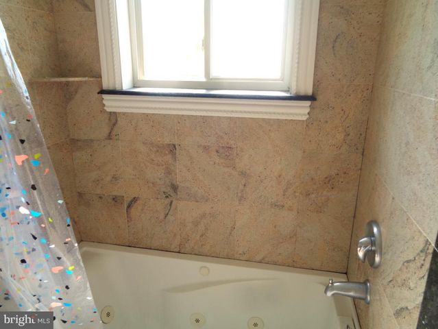 a bathroom with a window and a shower