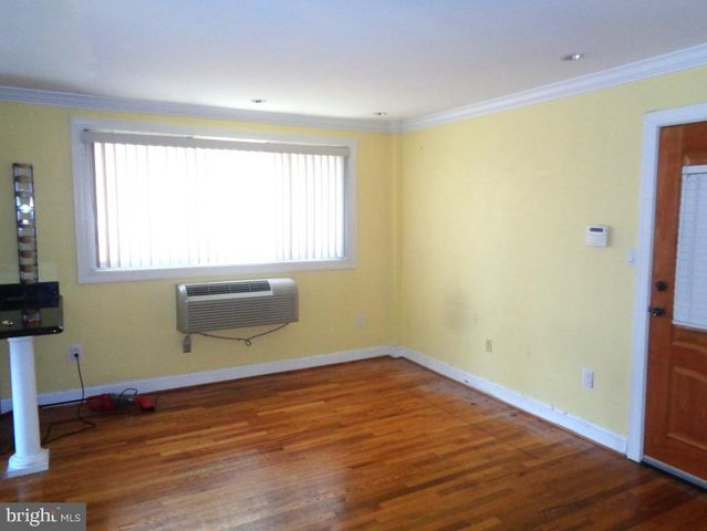 a view of a room with wooden floor and a window