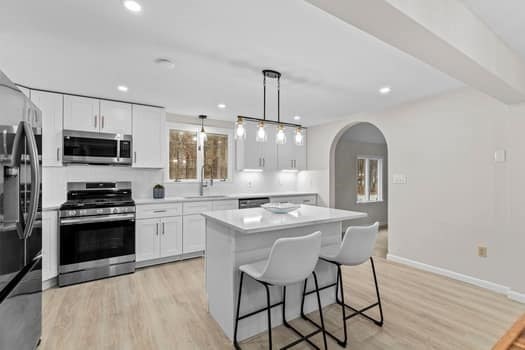 221 Plain Street Hanover, MA 02339 - Photo 12 of 29 a kitchen with stainless steel appliances granite countertop a stove a sink dishwasher a microwave oven with a dining table and chairs