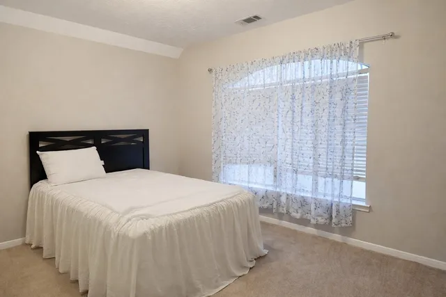 a bedroom with a bed and a window