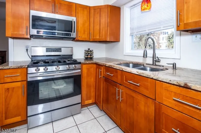 a kitchen with stainless steel appliances granite countertop a sink stove and microwave