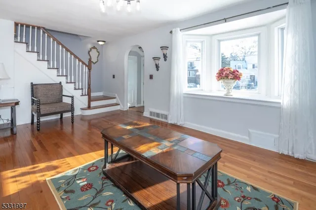a view of a dining room with furniture a chandelier and wooden floor