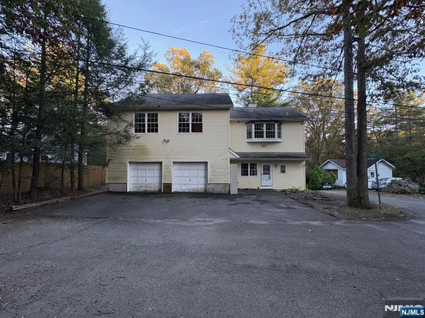 a view of a house with a large tree in front of it
