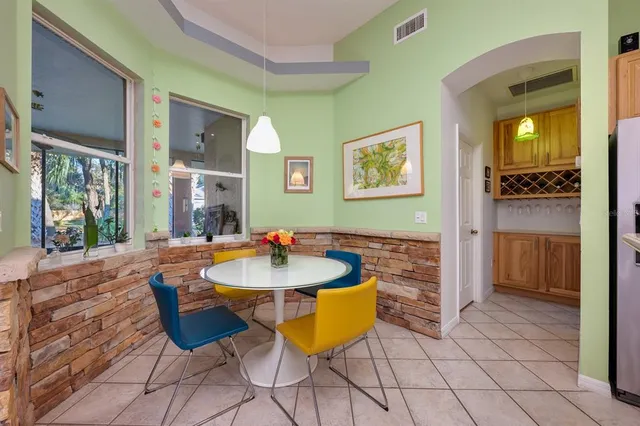a room with table chairs and a refrigerator