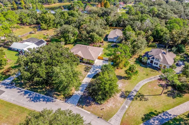 an aerial view of residential house with yard and swimming pool
