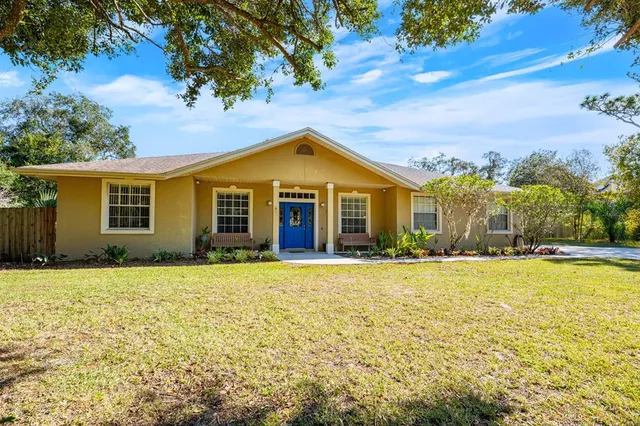 a front view of house with yard and trees around