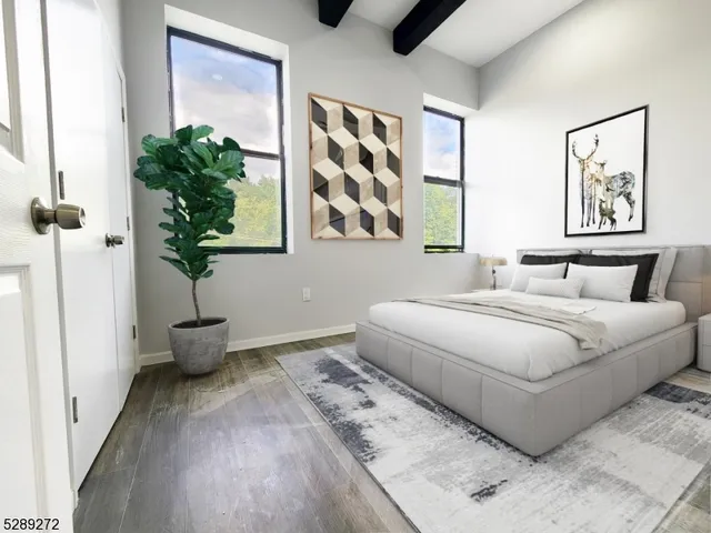 a bedroom with a large bed and a potted plant