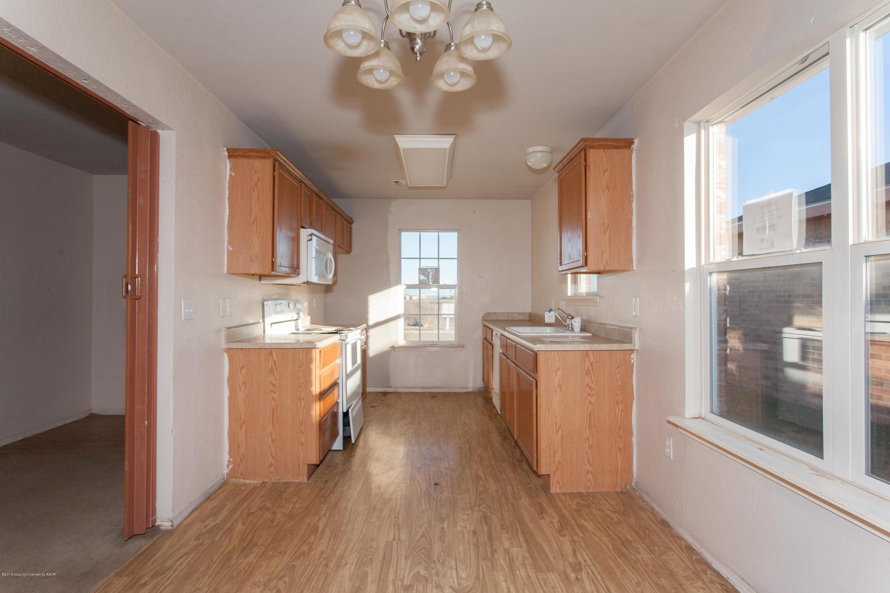 4810 Mammoth Lane Amarillo, TX 79110 - Photo 4 of 14 a kitchen with a refrigerator a sink dishwasher with a dining table and chairs