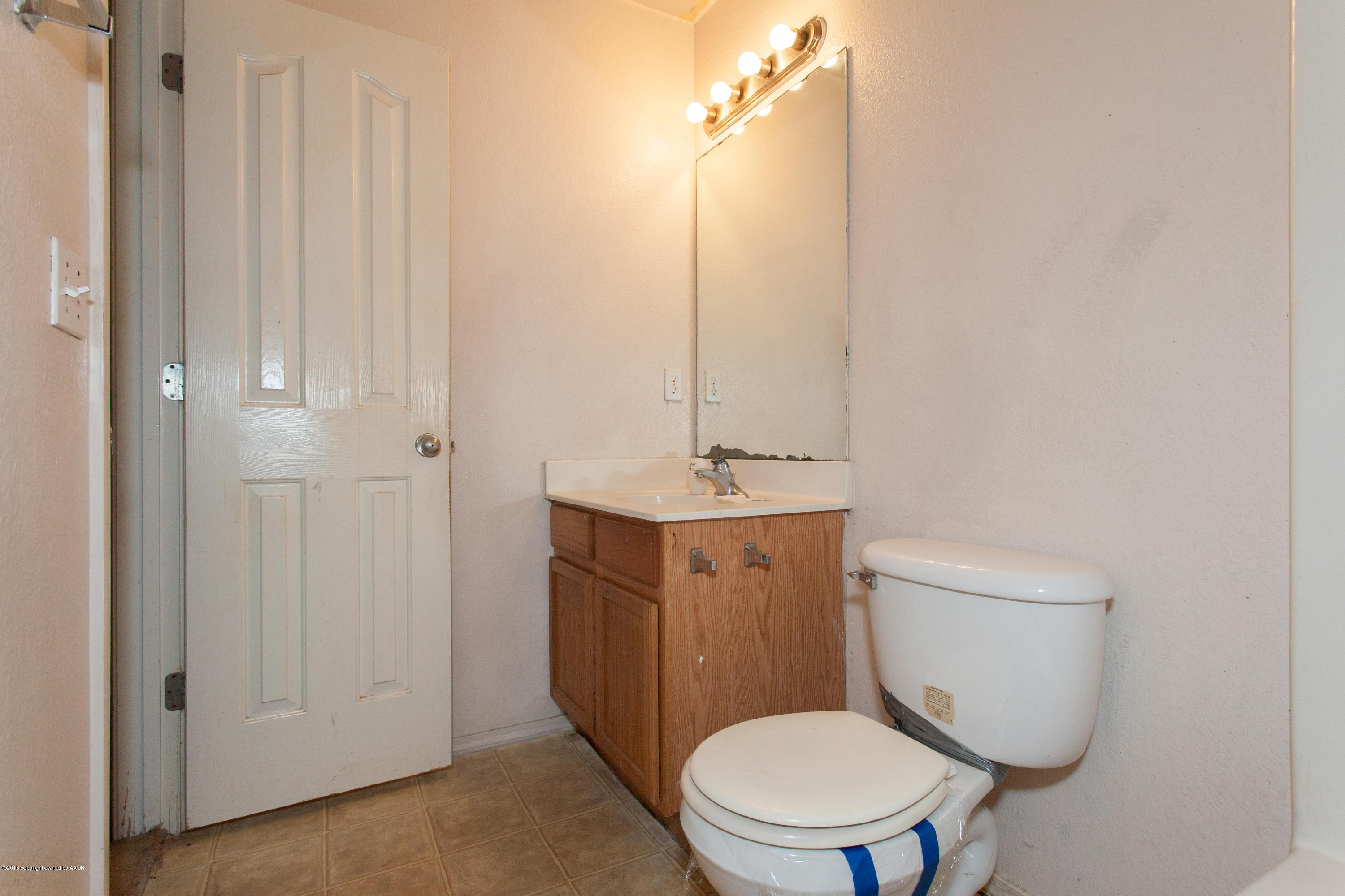 4810 Mammoth Lane Amarillo, TX 79110 - Photo 10 of 14 a bathroom with a toilet a sink and mirror