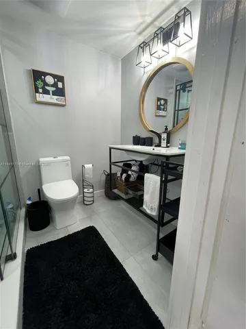 a bathroom with a toilet a sink and mirror